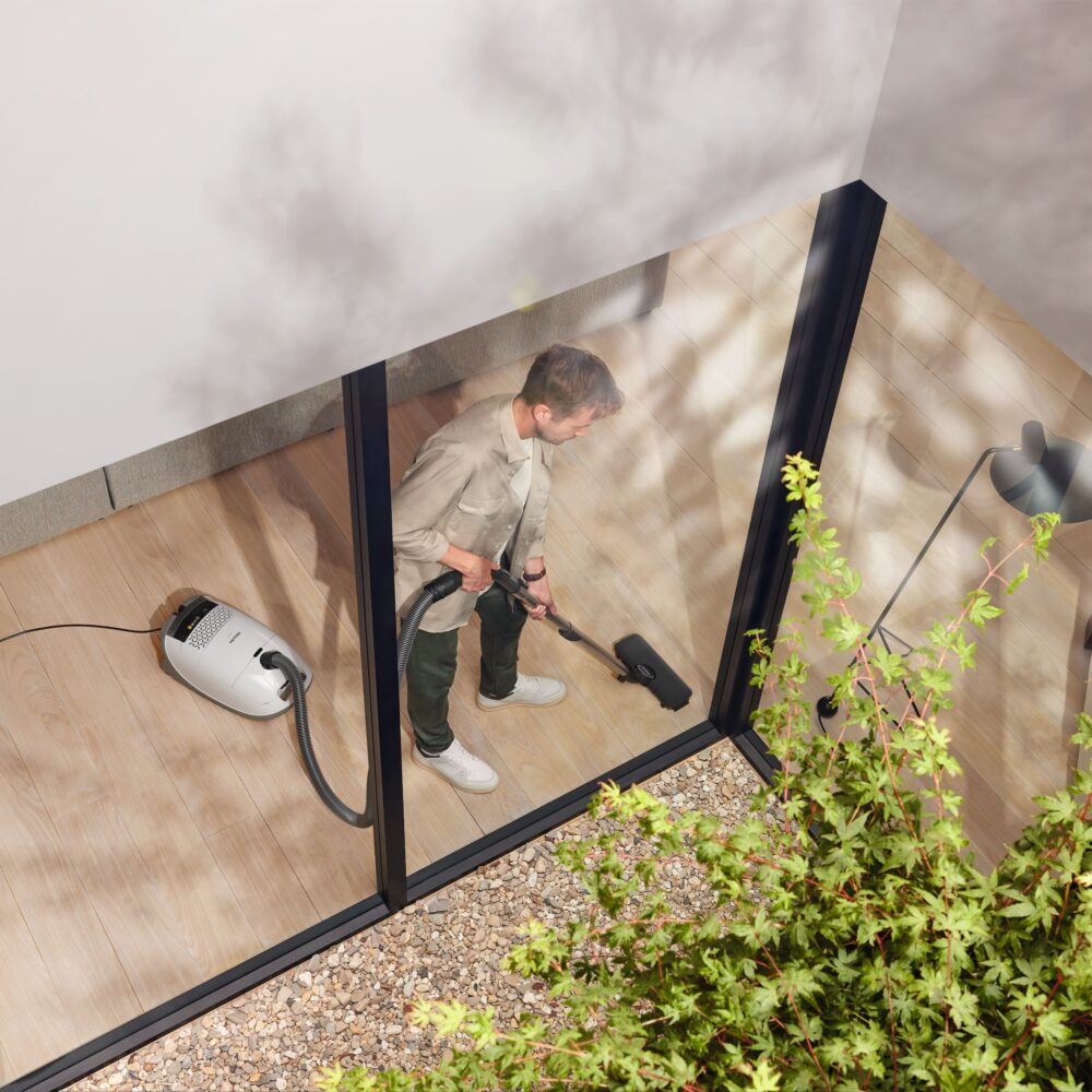 Miele Guard M1 AllFloor canister vacuum in use on a hard floor